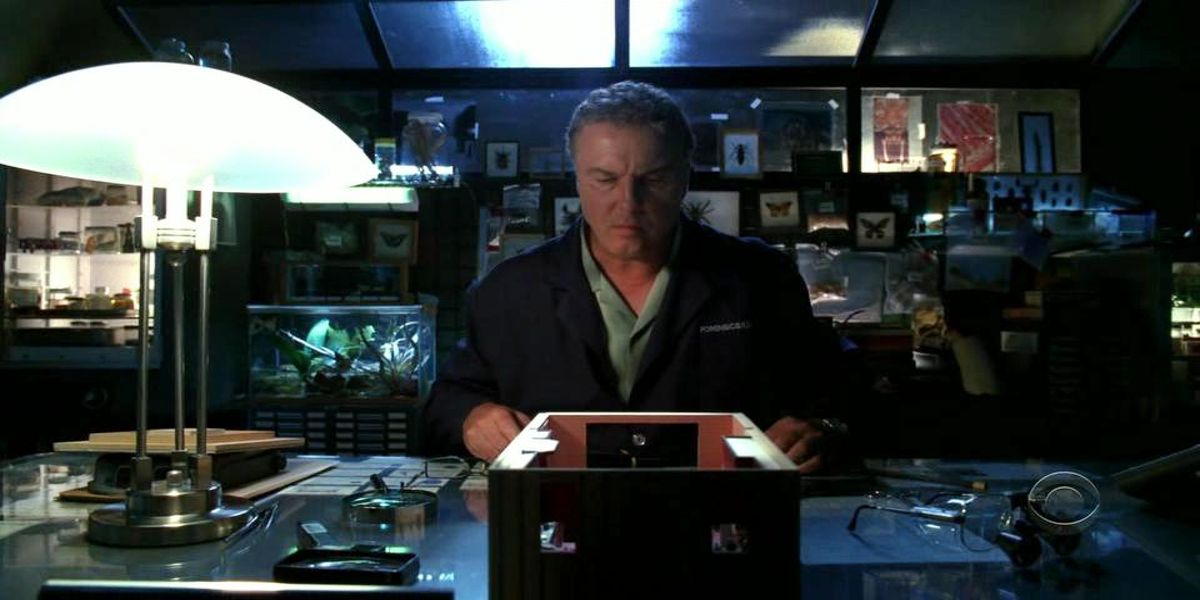 A man sitting in a desk looking down in CSI episode Built to Kill.