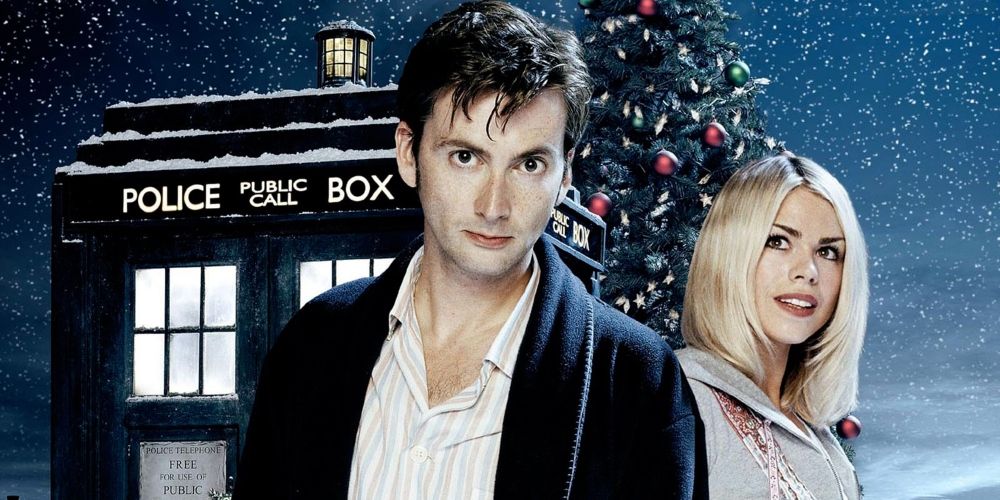 The Doctor and Rose Tyler stare at the camera in front of a snow-covered TARDIS and Christmas Tree.