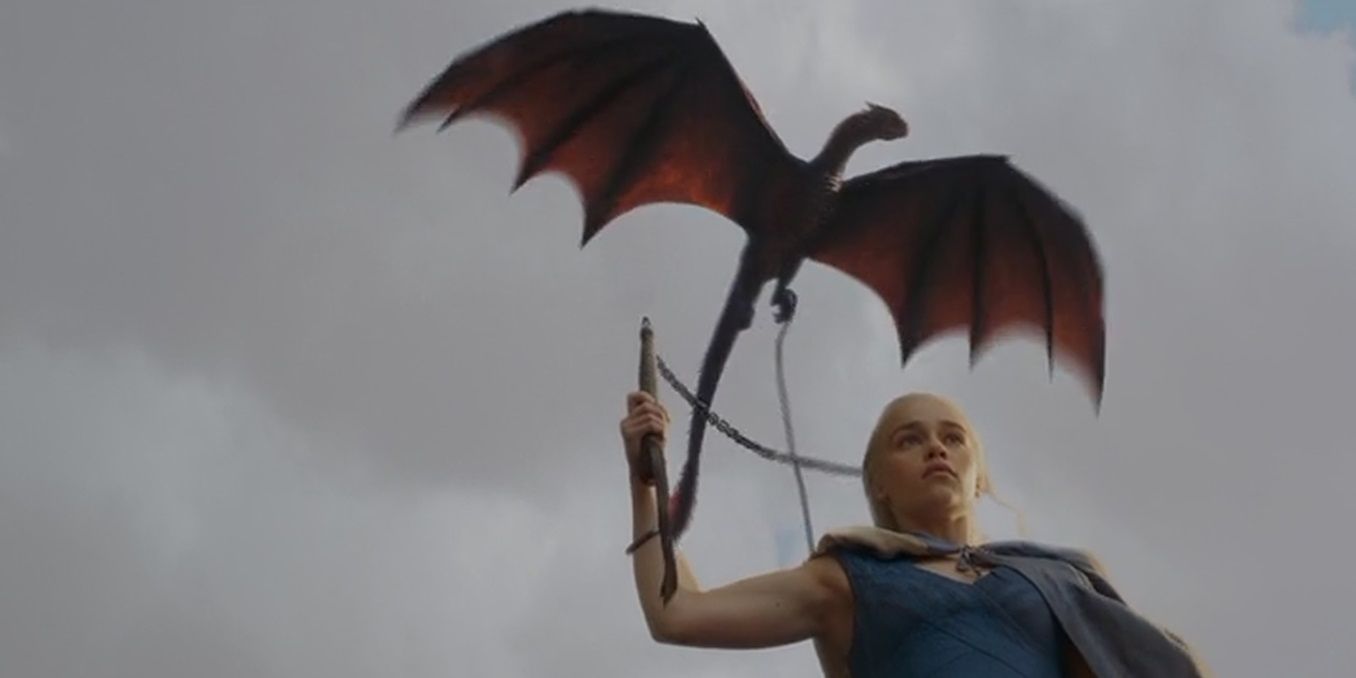 Daenerys holds a whip as a dragon flies overhead in Game of Thrones