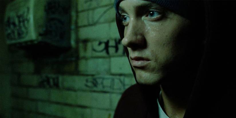 Eminem sitting by a wall with graffiti in 8 Mile.