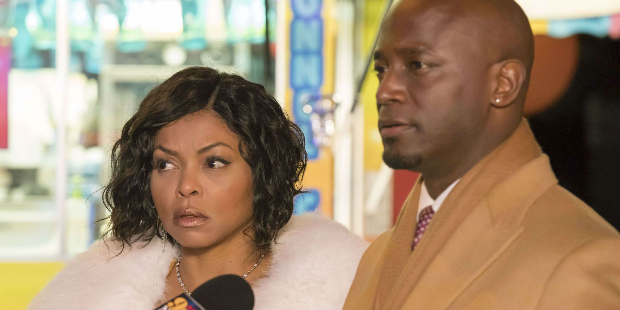 Taraji P Henson standing alongside Taye Diggs, who has a microphone pointed at him, on Empire
