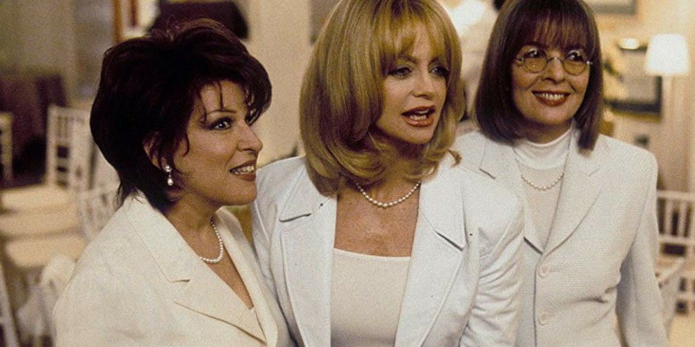 Bette Midler, Goldie Hawn and Diane Keaton smiling in white suits in Five Wives Club