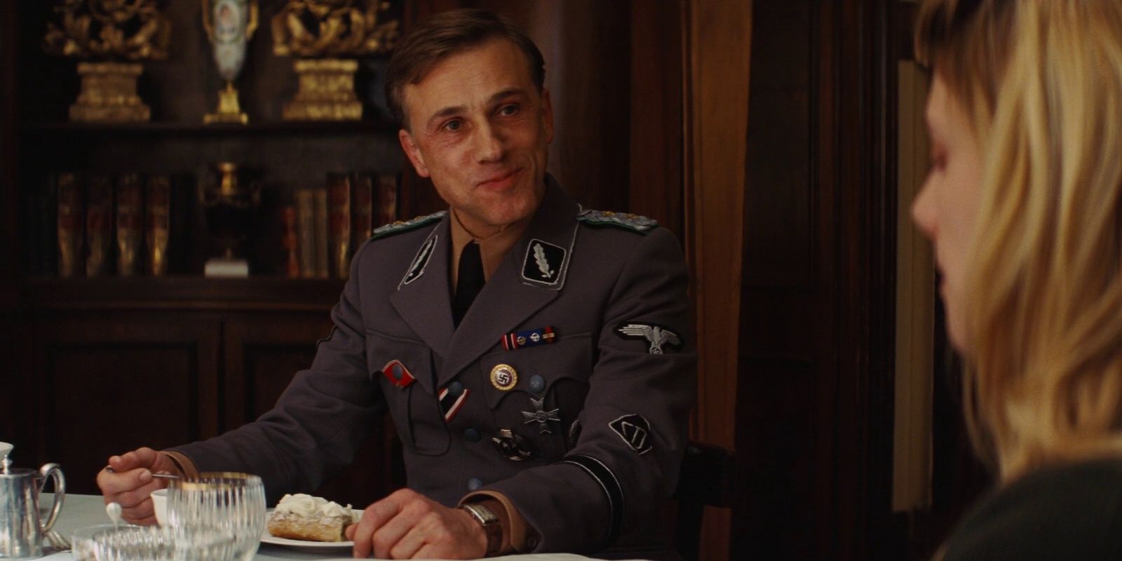 Hans Landa (Christoph Waltz) subtly interrogates Shosanna (Melanie Laurent) during a meal in Inglorious Basterds.