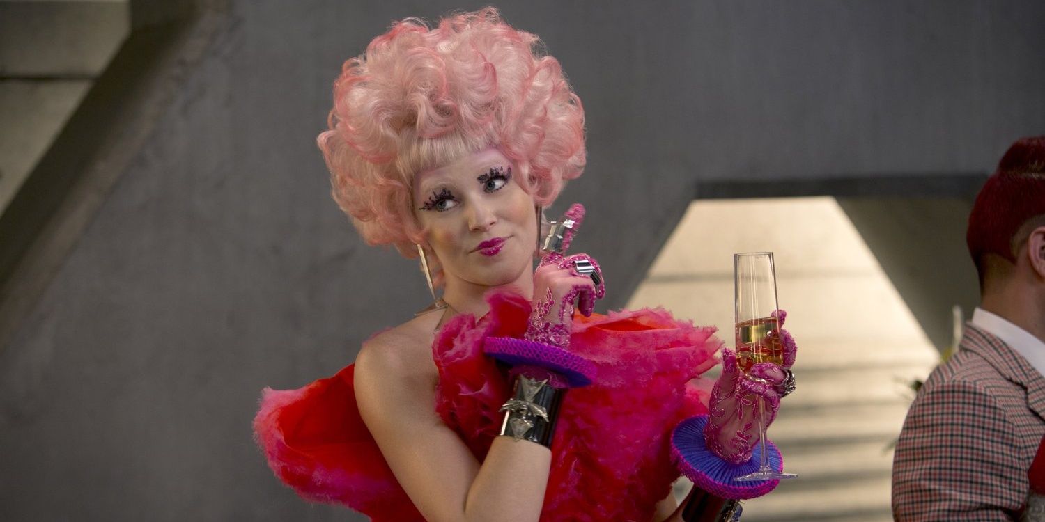 Elizabeth Banks in a pink wig and pink dress as Effie in the Hunger Games franchise