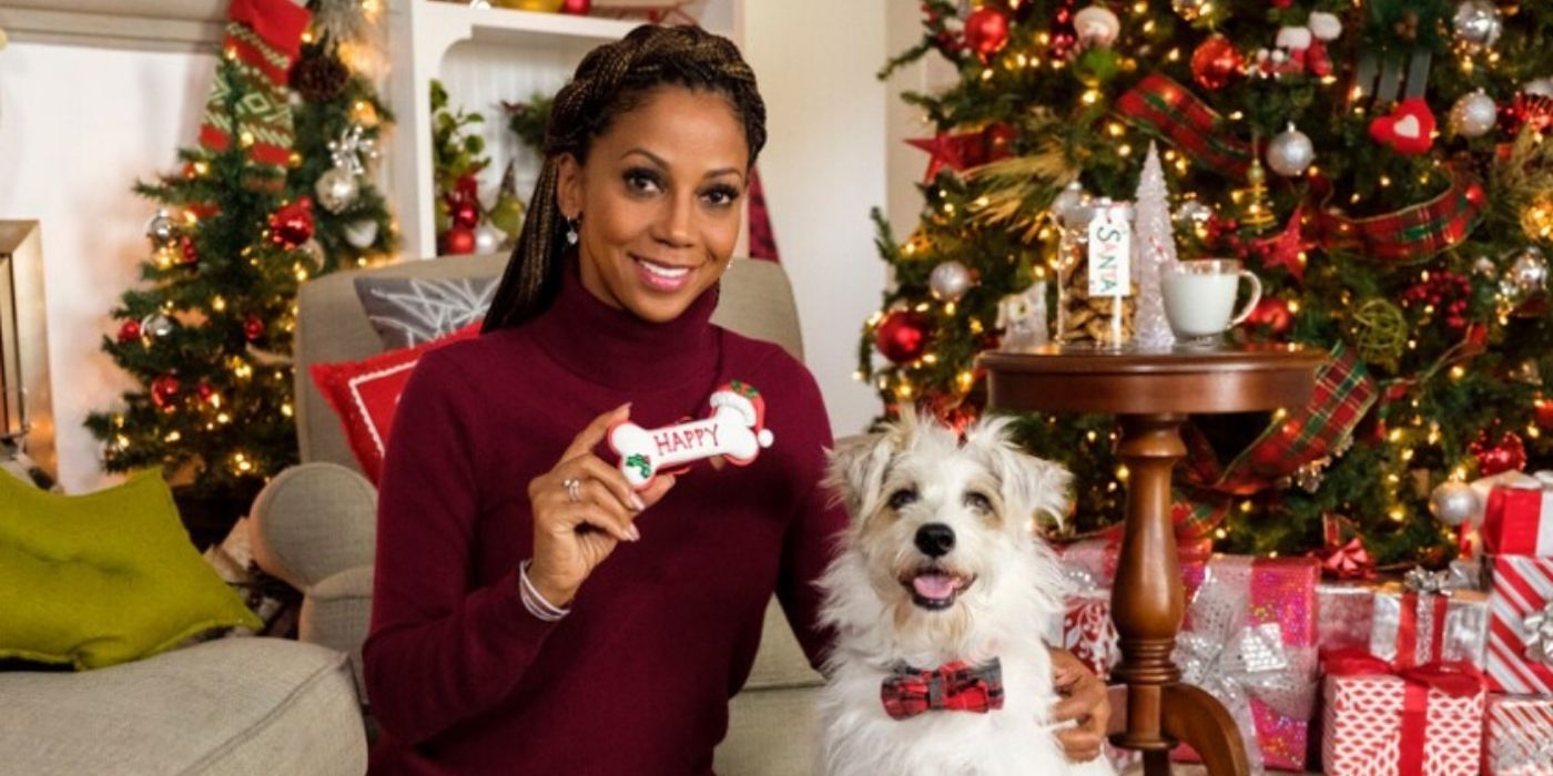 Holly Robinson Peete sorrindo com um cachorro para um filme de Natal da Hallmark