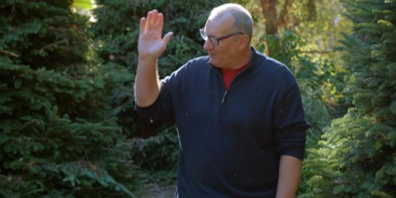 Jay waving to someone off camera in an episode of Modern Family