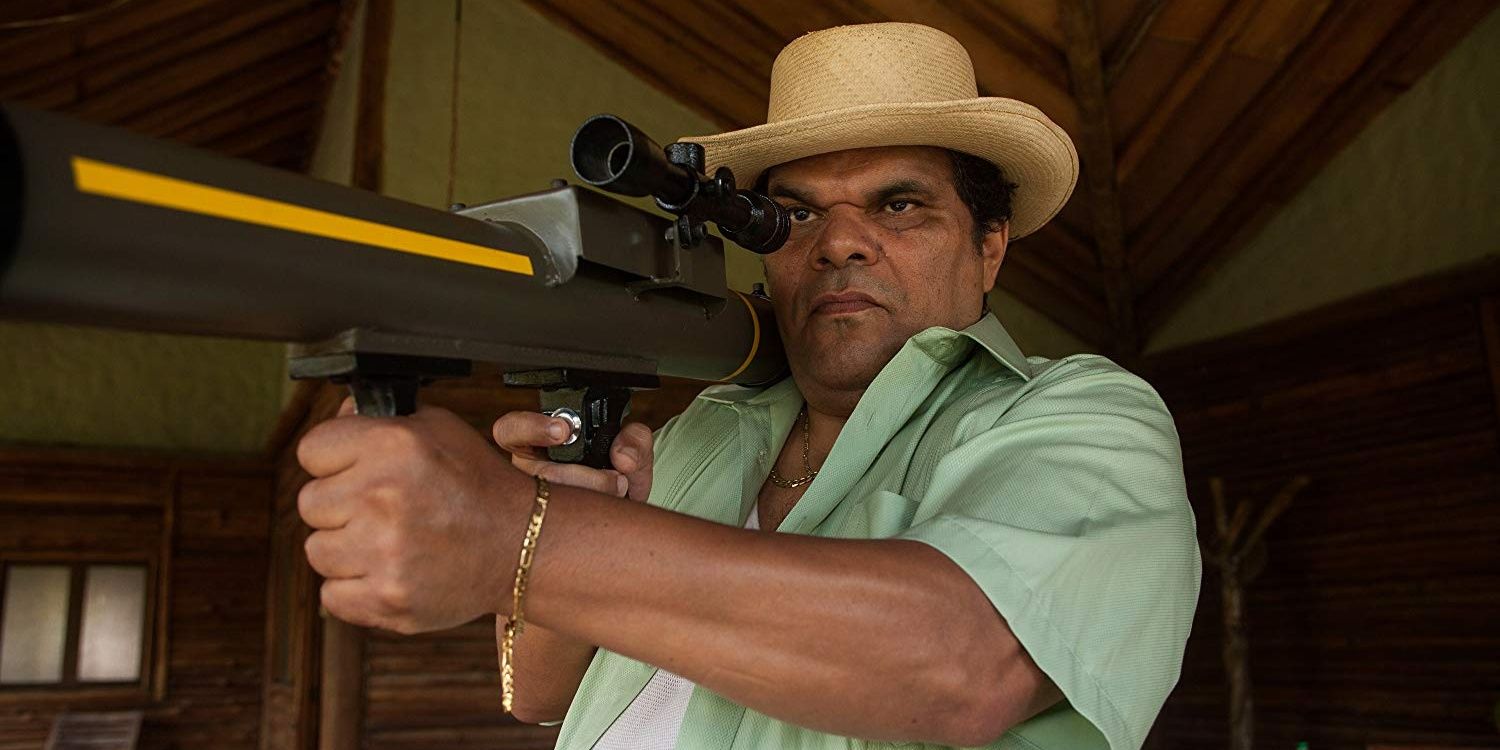 Luis Guzman as Jose Gacha aims a weapon from Narcos 