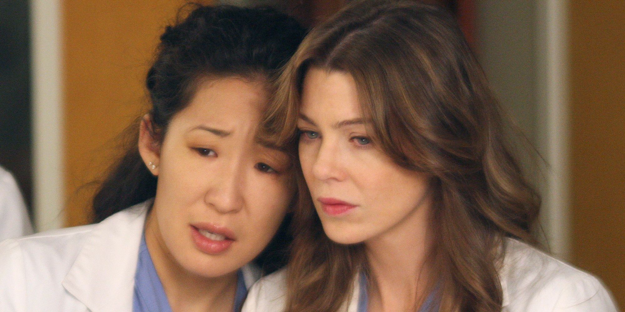Cristina and Meredith with their heads together looking at something in Grey&rsquo;s Anatomy