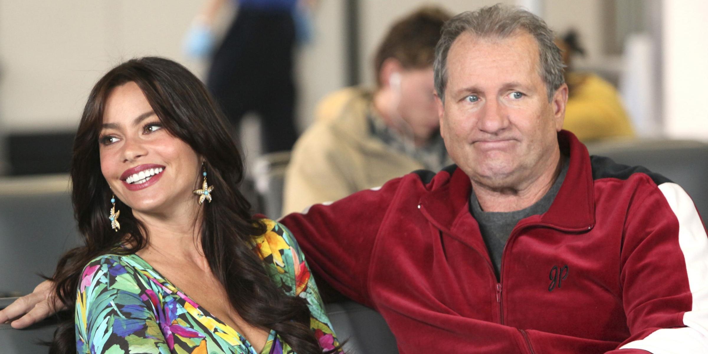 An image of Jay and Gloria sitting together in the airport in Modern Family