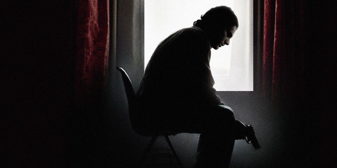 Avner (Eric Bana) sentado em uma cadeira segurando uma arma em Munique
