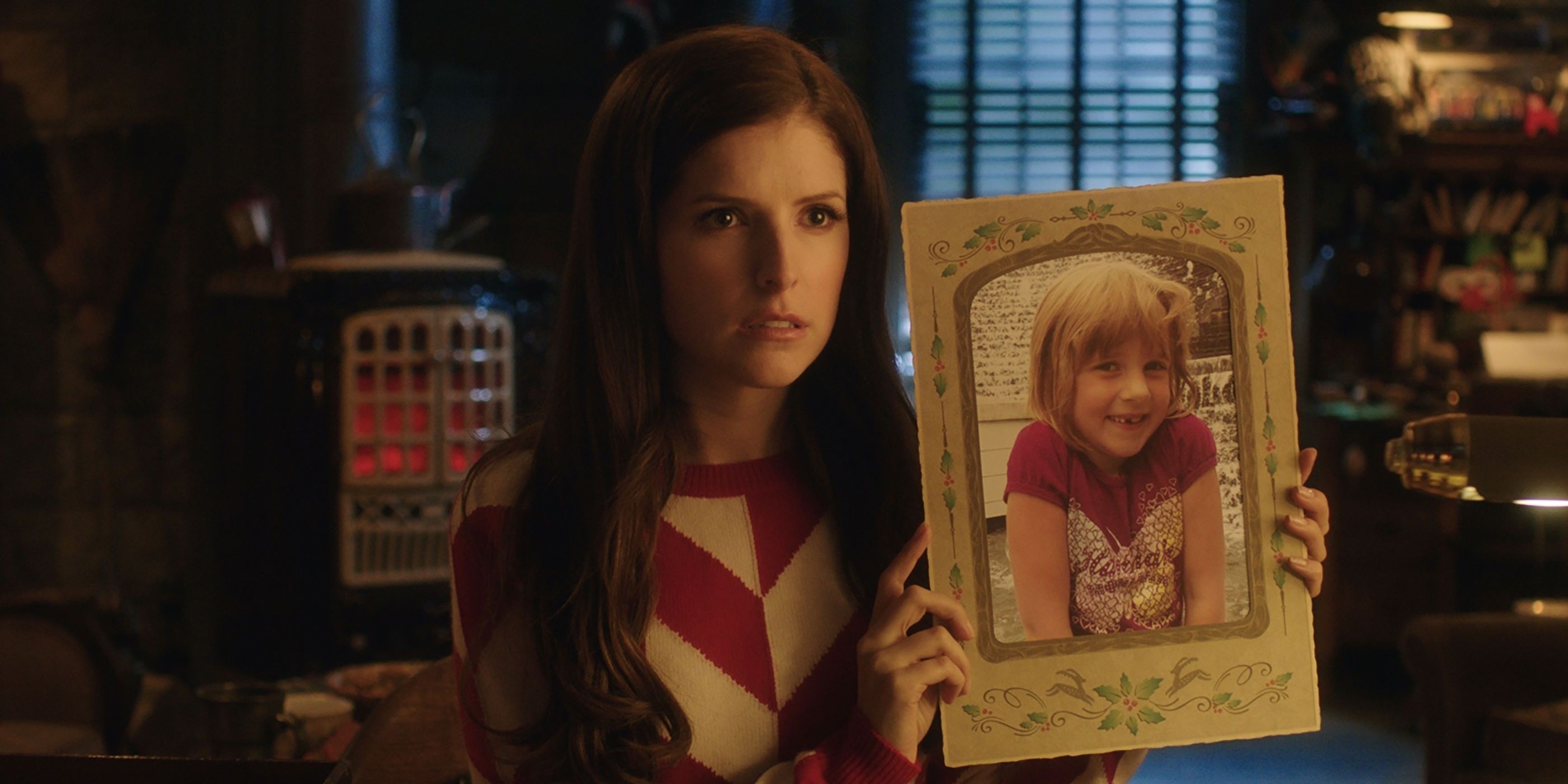 Anna Kendrick in Noelle holding up a picture of a young girl