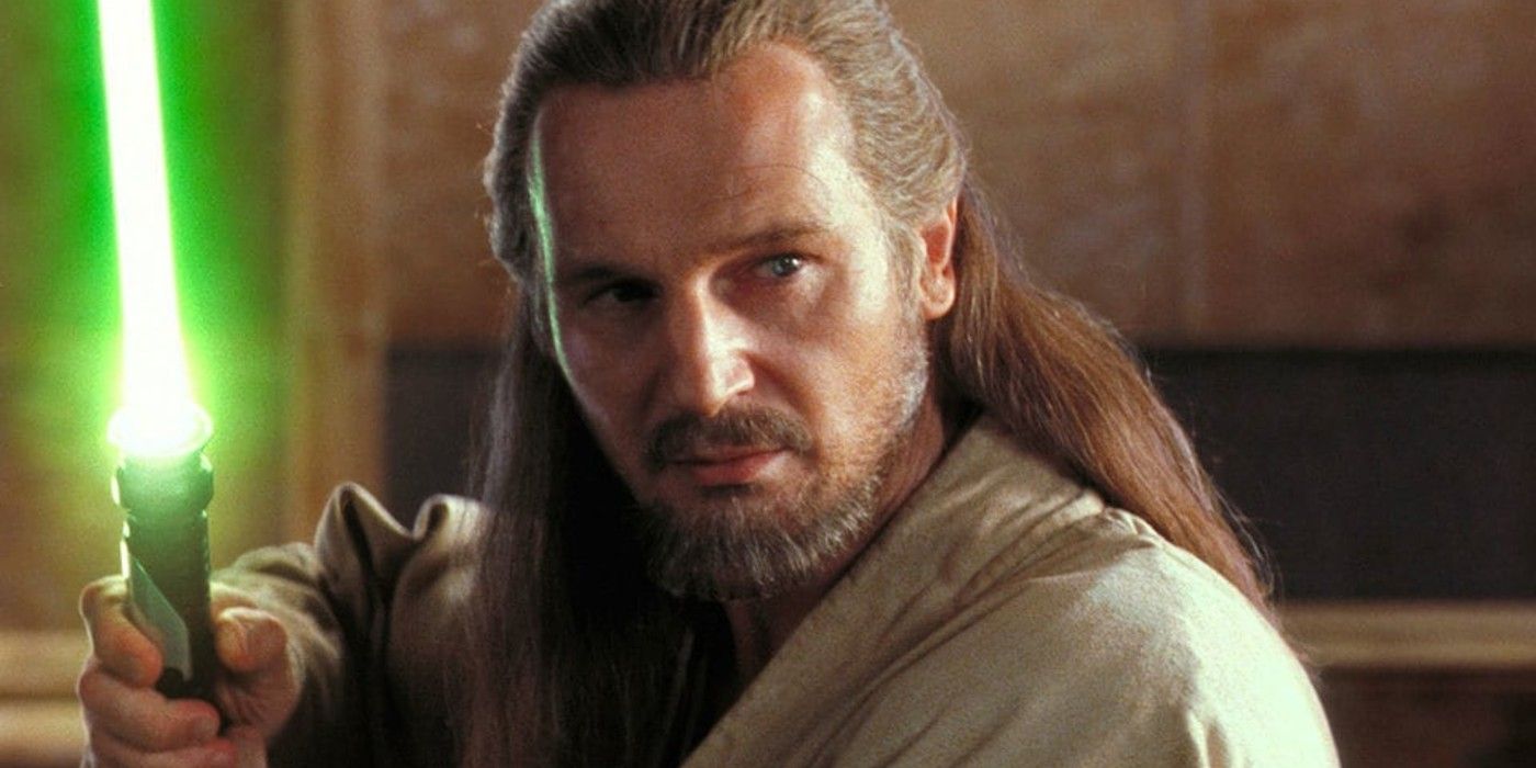 Qui-Gon holding a lightsaber up in Star Wars