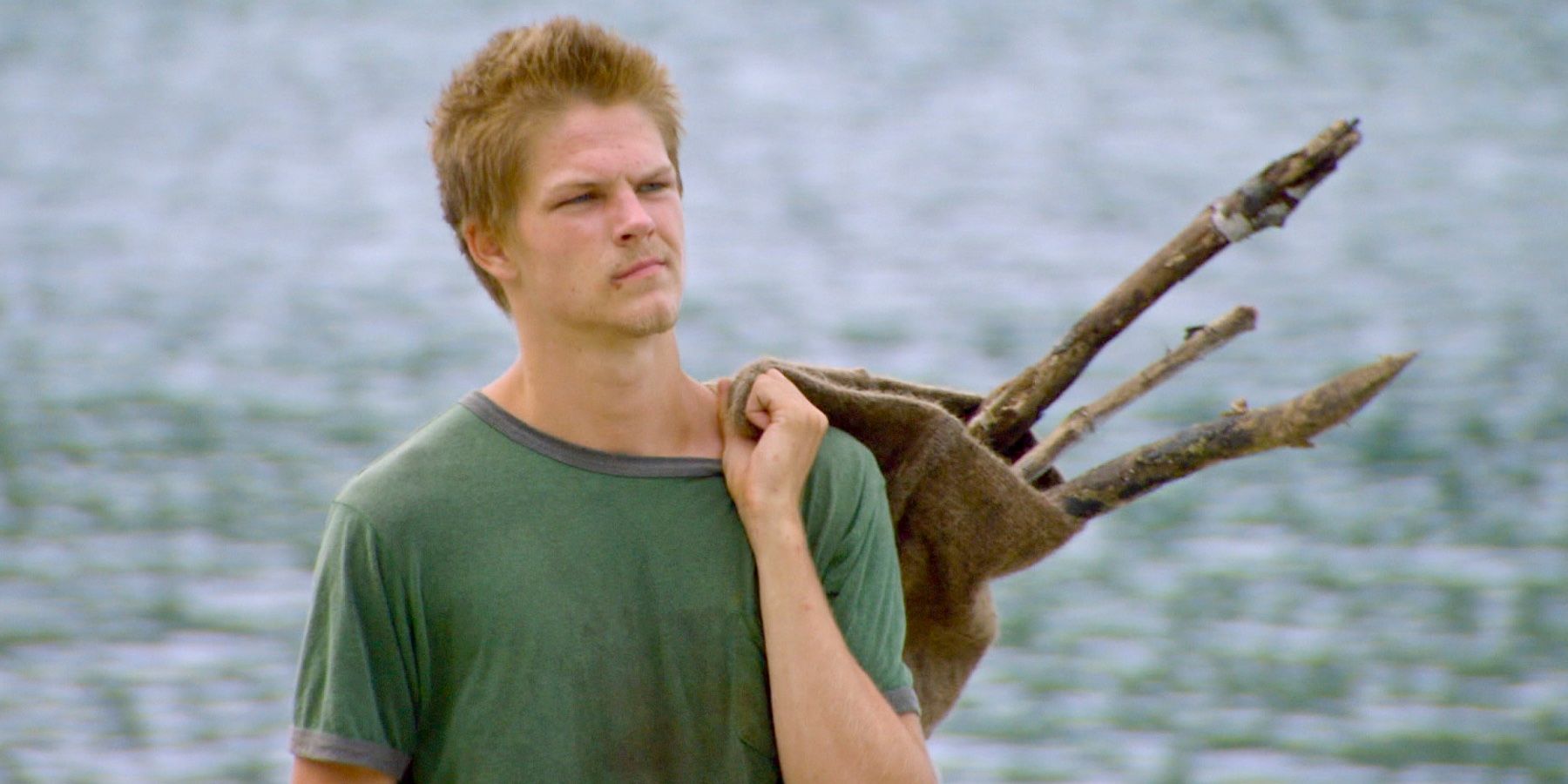 Spencer segurando varas por cima do ombro em Survivor