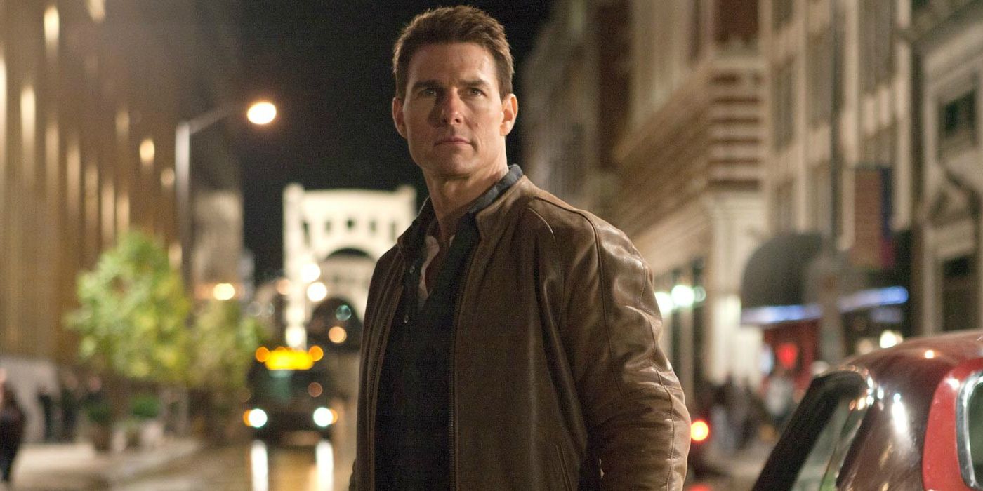 Jack Reacher stand in the middle of a street looking serious