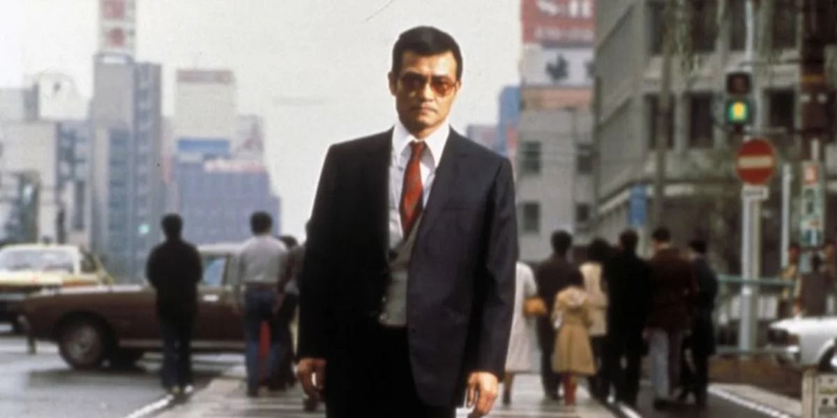 Iwao walks along the middle of the street in Vengeance Is Mine