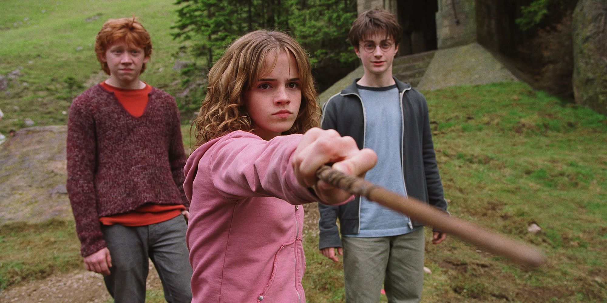 Hermione apontando sua varinha para Malfoy enquanto Harry e Ron olham