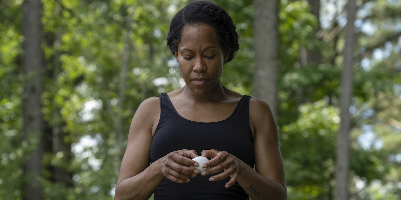 Regina King cracking an egg by the pool in Watchmen