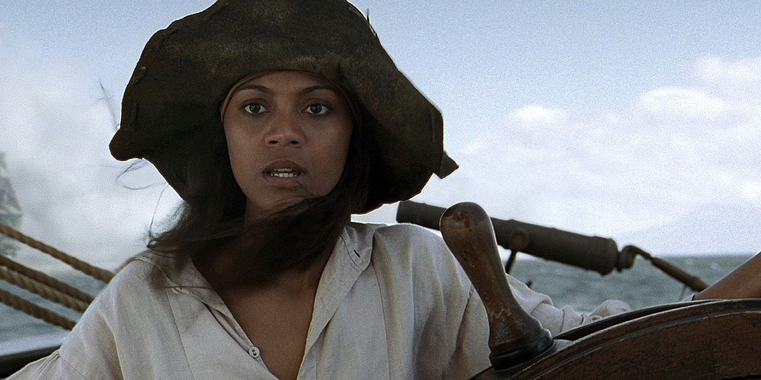 Zoe Saldana as Anamaria standing at the wheel of a ship in Pirates of the Caribbean