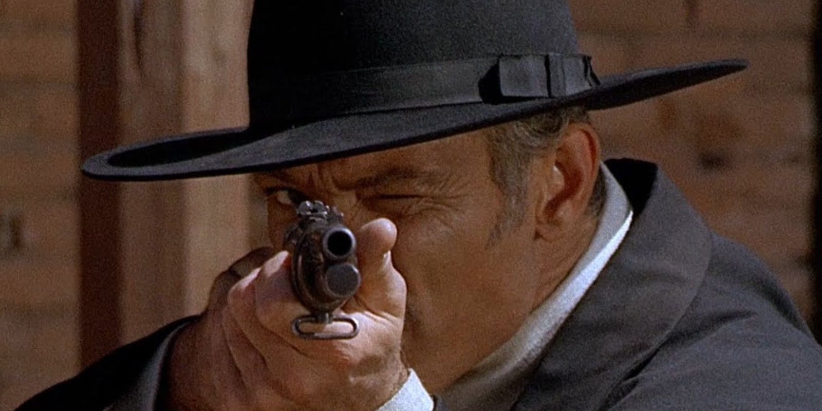 Angel Eyes (Lee van Cleef) aims a pistol at the screen in The Good, The Bad and the Ugly