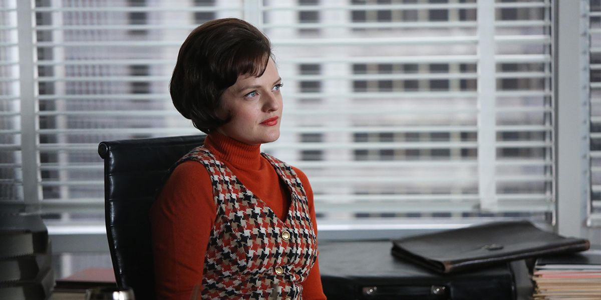 Peggy sits at a desk in Mad Men.