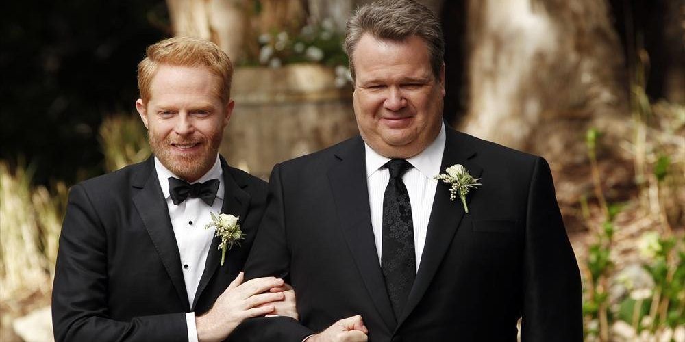 An image of Cam and Mitchell walking down the aisle in Modern Family