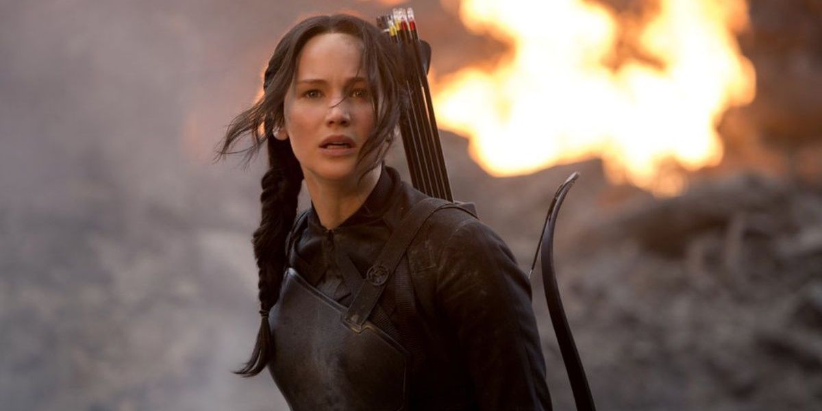 Katniss Everdeen, played by Jennifer Lawrence, standing in front of a wildfire