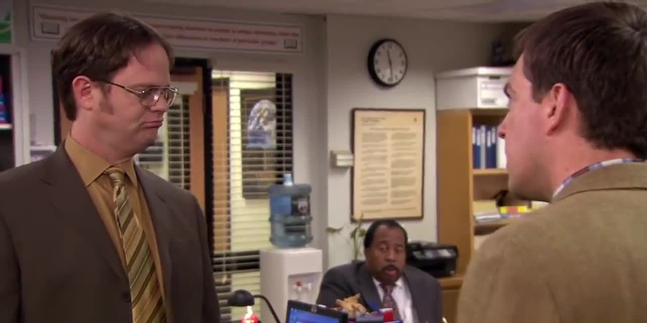 Dwight and Andy argue in the middle of the office