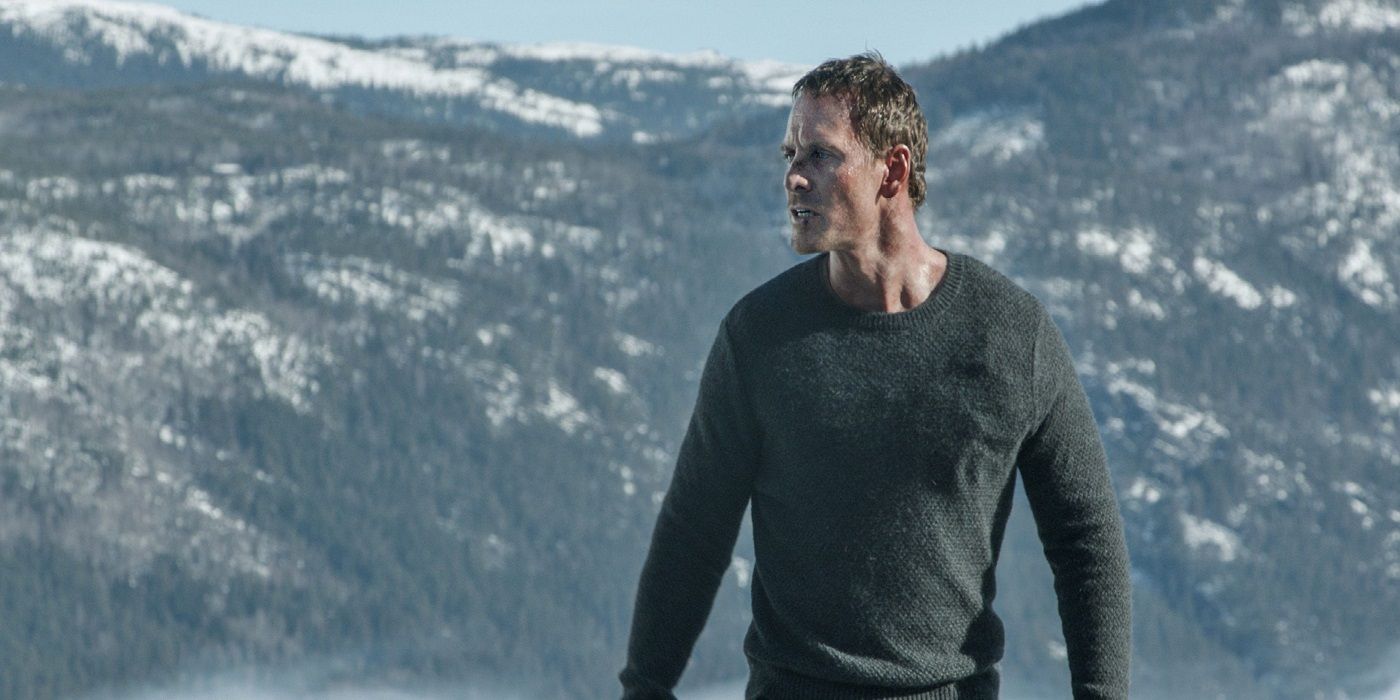Michael Fassbender stands in front of a mountain range in The Snowman