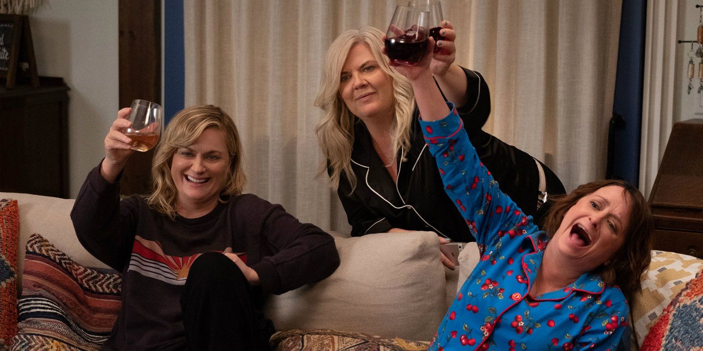 Abby, Val and Rebecca holding up wine on the couch in Wine Country