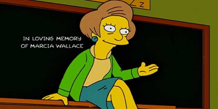 Mrs. Krabappel sitting on her desk with her legs crossed and Marcia Wallace's tribute written on the blackboard in The Simpsons