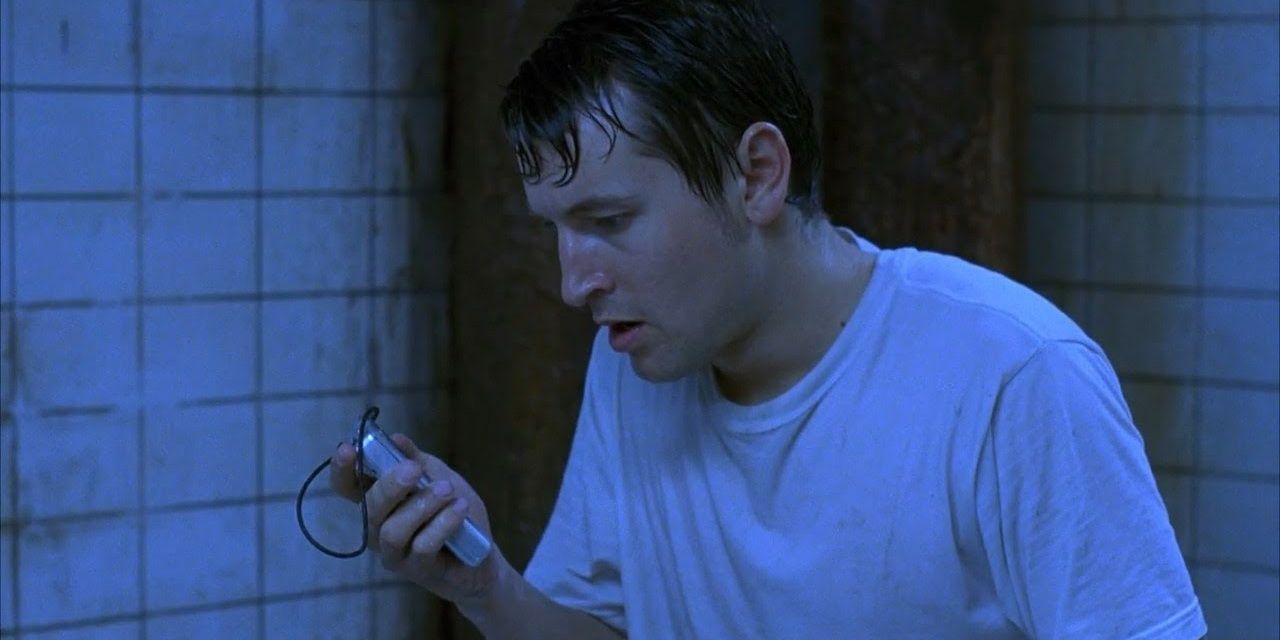 Adam (Leigh Whannell) listens to tape recorder in basement in Saw
