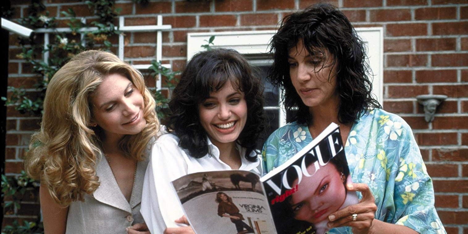 Angelina Jolie and two women looking at Gia Carangi's Vogue magazine in Gia