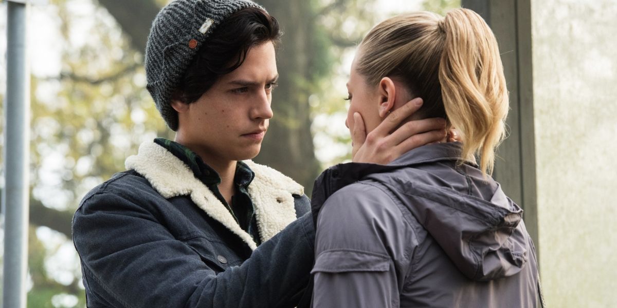 Jughead holds Betty's face in Riverdale.