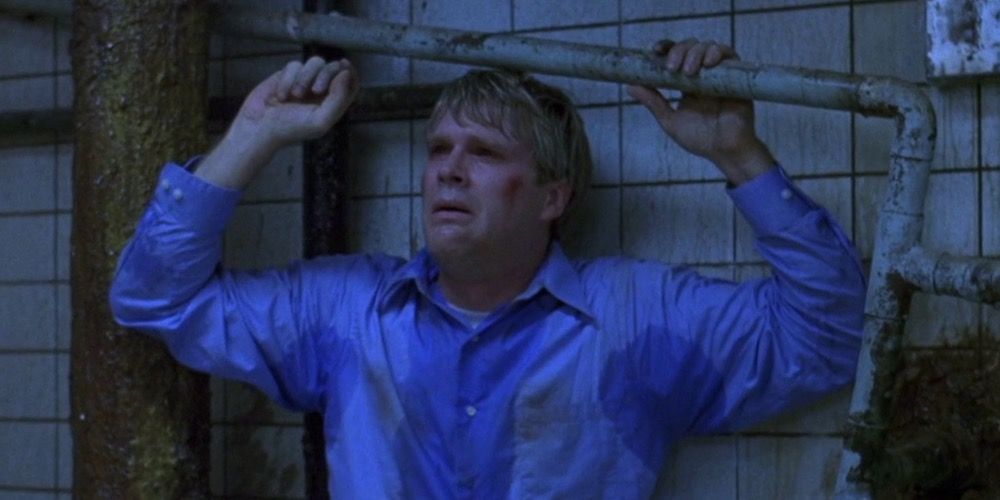 Gordon cries and holds a pipe in Saw