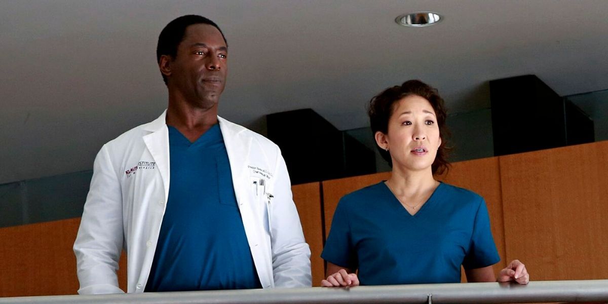 Cristina and Burke standing on a balcony in Grey's Anatomy