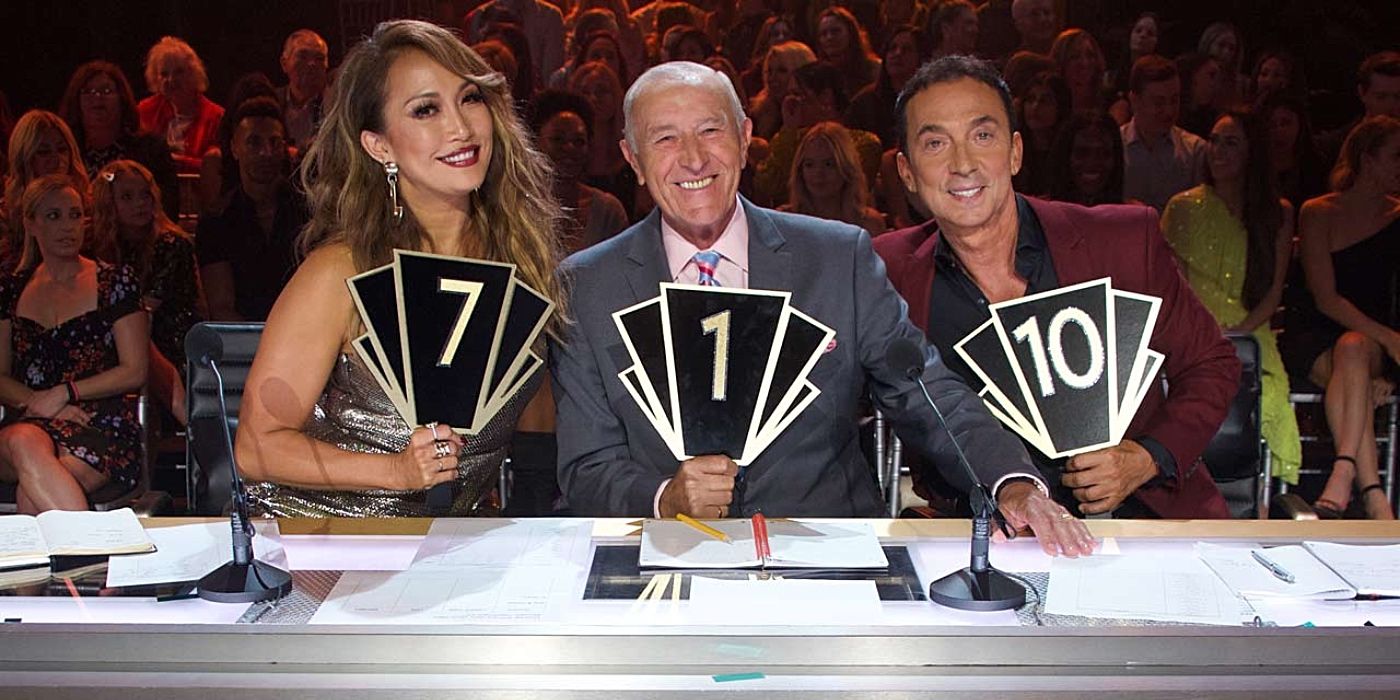 Carrie Ann, Len and Bruno smile and hold the judge's handle in Dancing with the Stars