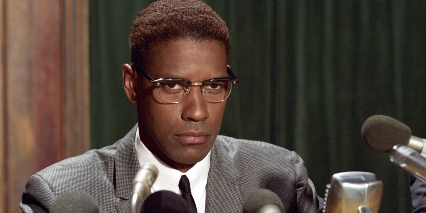 Malcolm X sitting behind mics in Malcolm X.