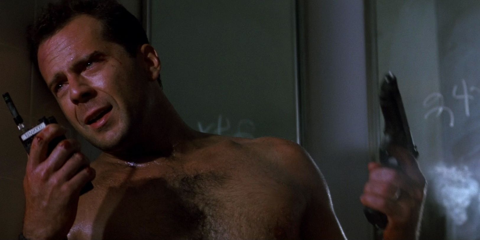 Shirtless John McClane talking into a walkie-talkie in Die Hard