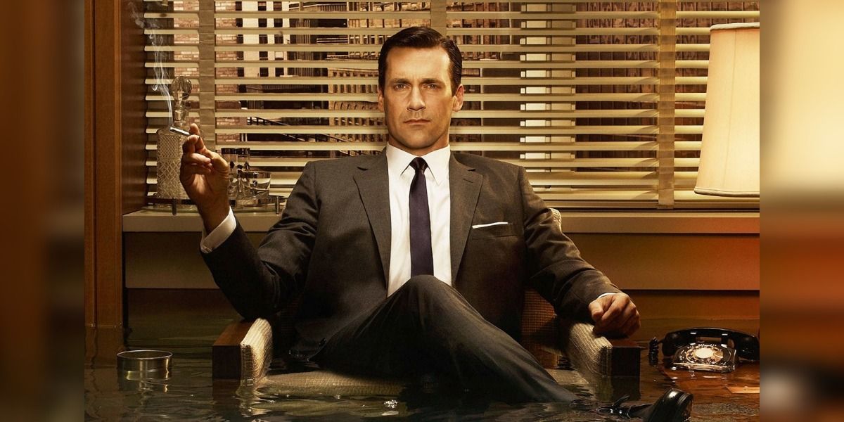 Don Draper from Mad Men sits in a chair looking at the camera with a cigarette.