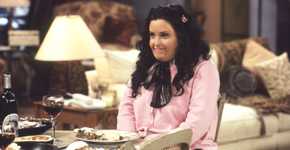 Courteny Cox wearing a fat suit and sitting at the dinner table as Fat Monica in Friends.