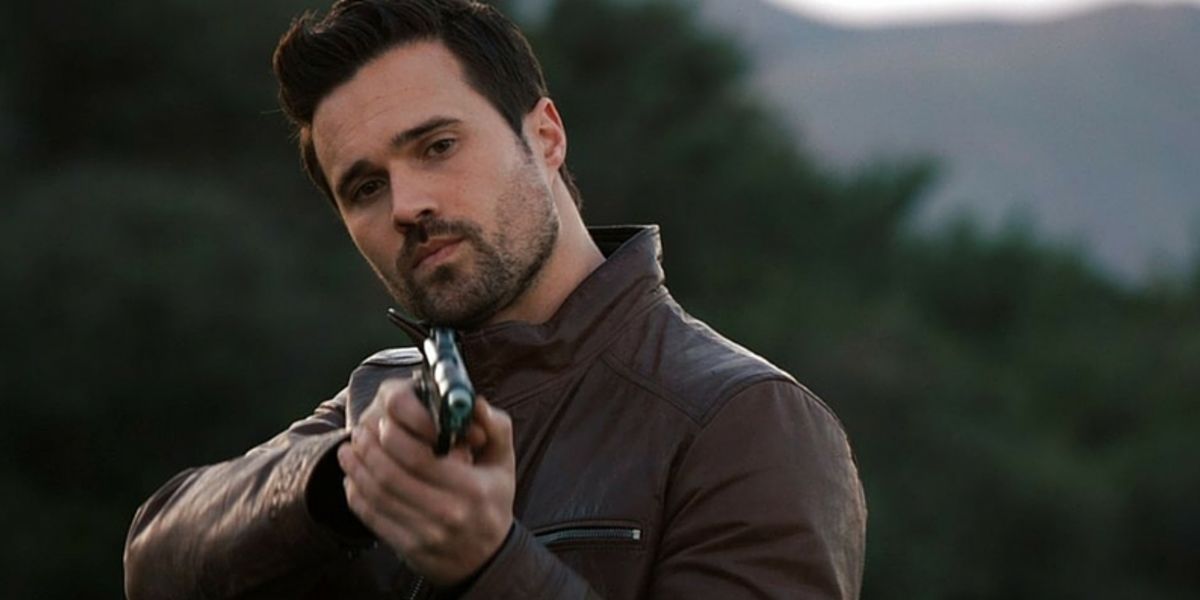 Grant Ward in a leather jacket aiming his gun