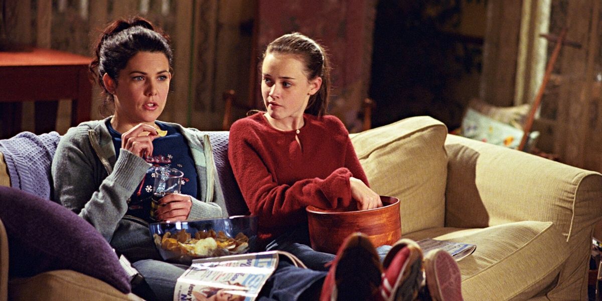 Lorelai e Rory sentadas no sofá juntas em Gilmore Girls