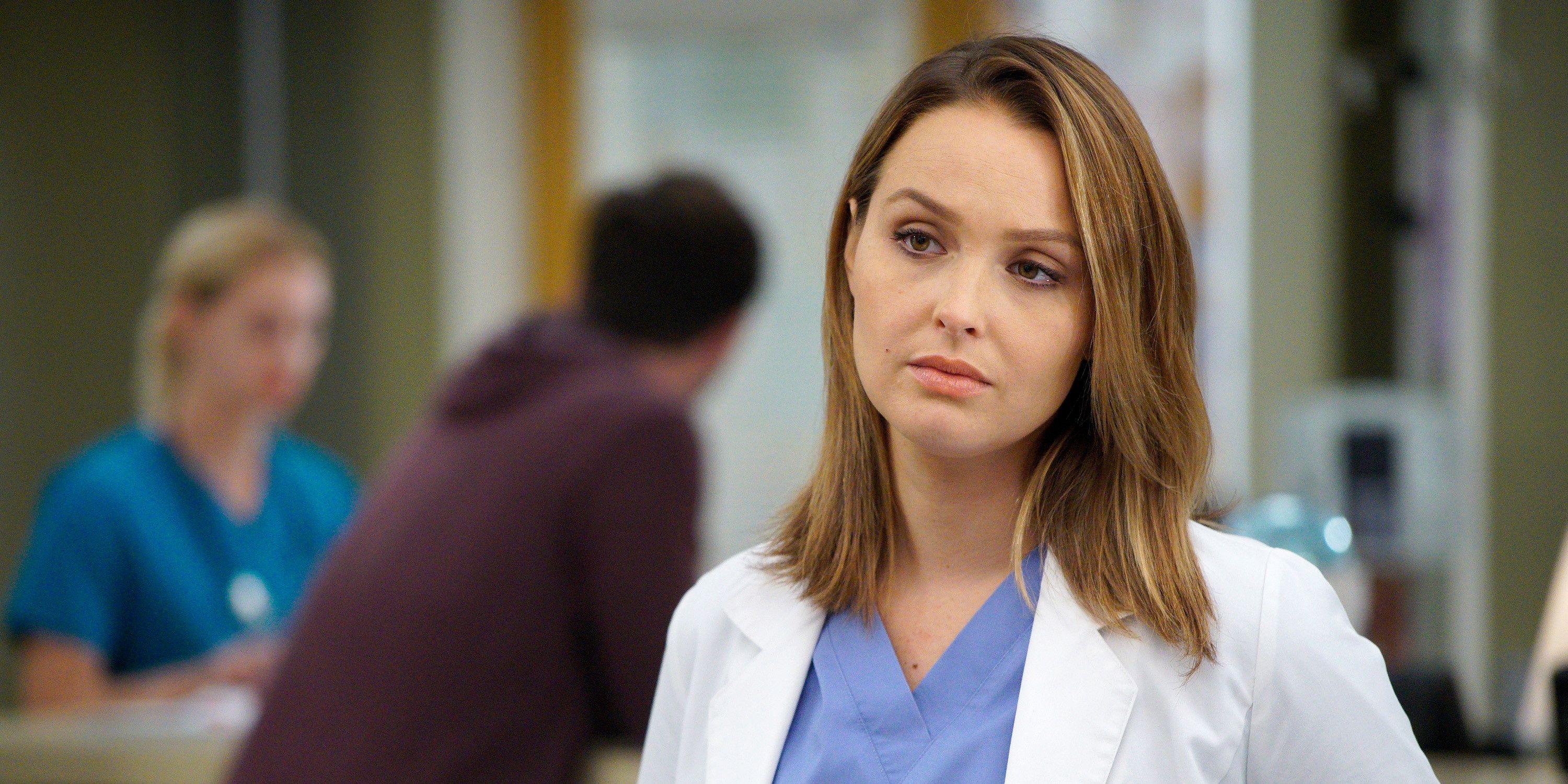 Jo in her scrubs and coat looking thoughtful