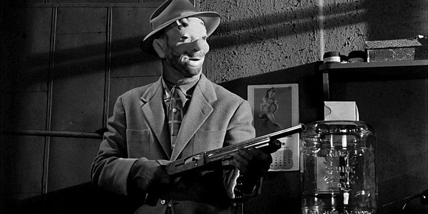 A man in a clown mask holds a gun from The Killing 