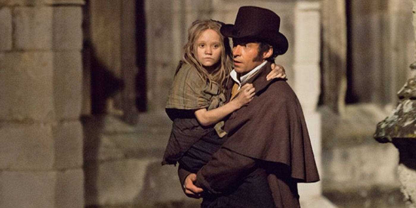 Hugh Jackman como Jean Valjean segura uma jovem Cosette em Os Miseráveis