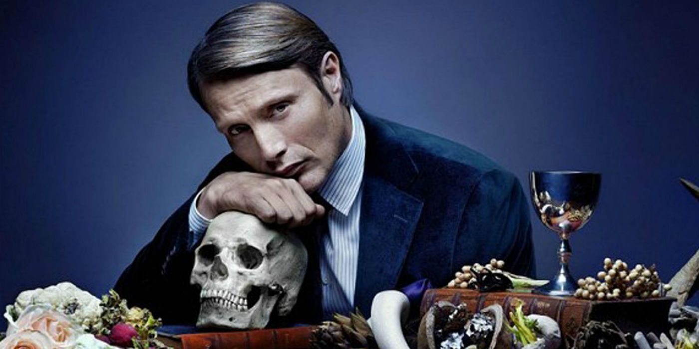 Mads Mikkelsen as Hannibal leaning on a skull in Hannibal 