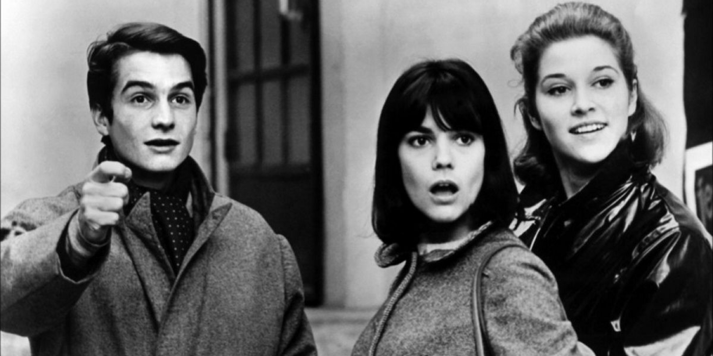 A man and two women looking at something offscreen in Masculin, Féminin.