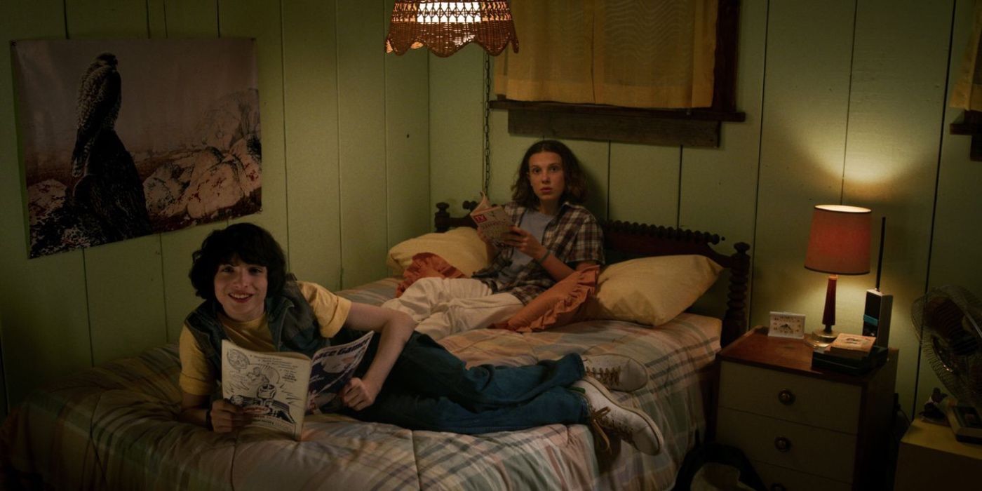 Mike and Eleven sitting on a bed on Stranger Things