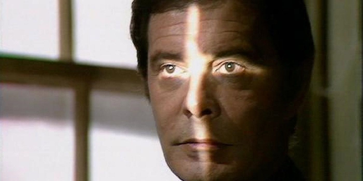 Louis Jourdan as Count Dracula staring at a cross-shaped light.