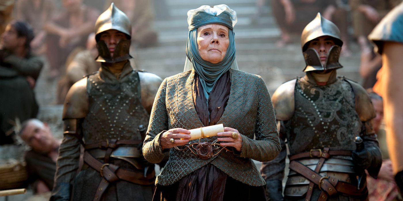 Olenna Tyrell stands flanked by two guards, scroll in hand